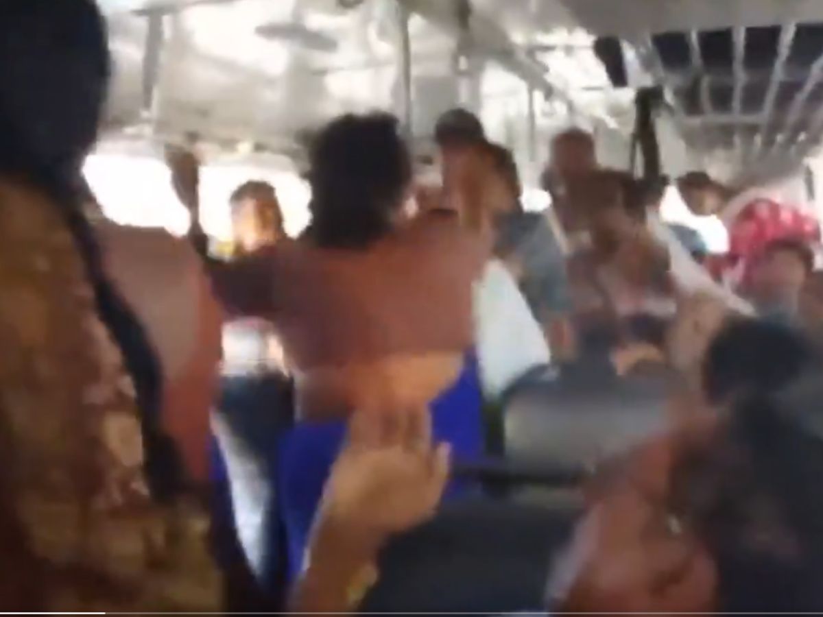 Women holding hair and fighting for a seat in AP